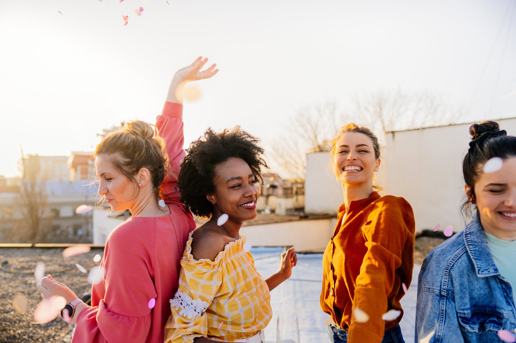 Women dancing outside and throwing petals in the air